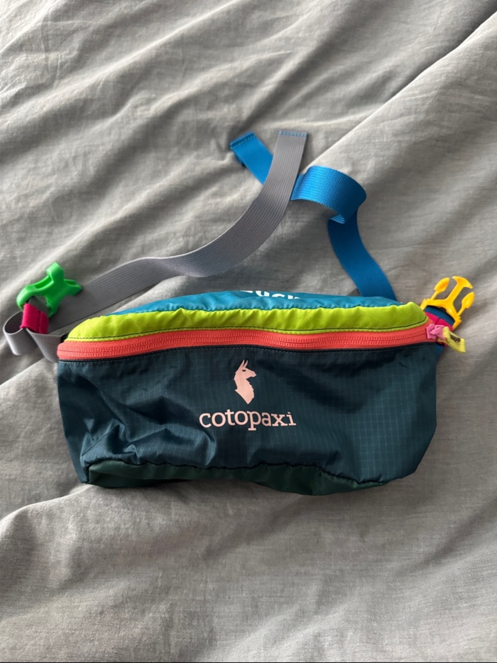 cotopaxi teal waist pack with lime trim and pink logo